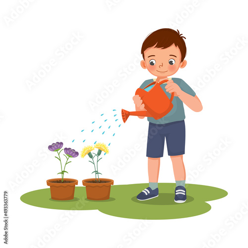 Happy cute little boy watering plants flowers in the pot with watering can in the garden
