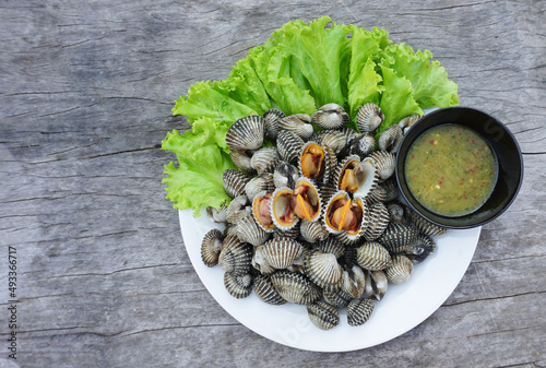 Photography Fresh cockle on a white plate, high protein seafood with salad and healthy seafood dipping sauce