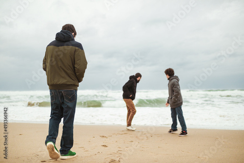 Friends playing around during beach winter walk