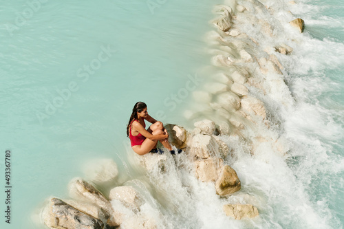 Woman sitting in scenic river rapids photo