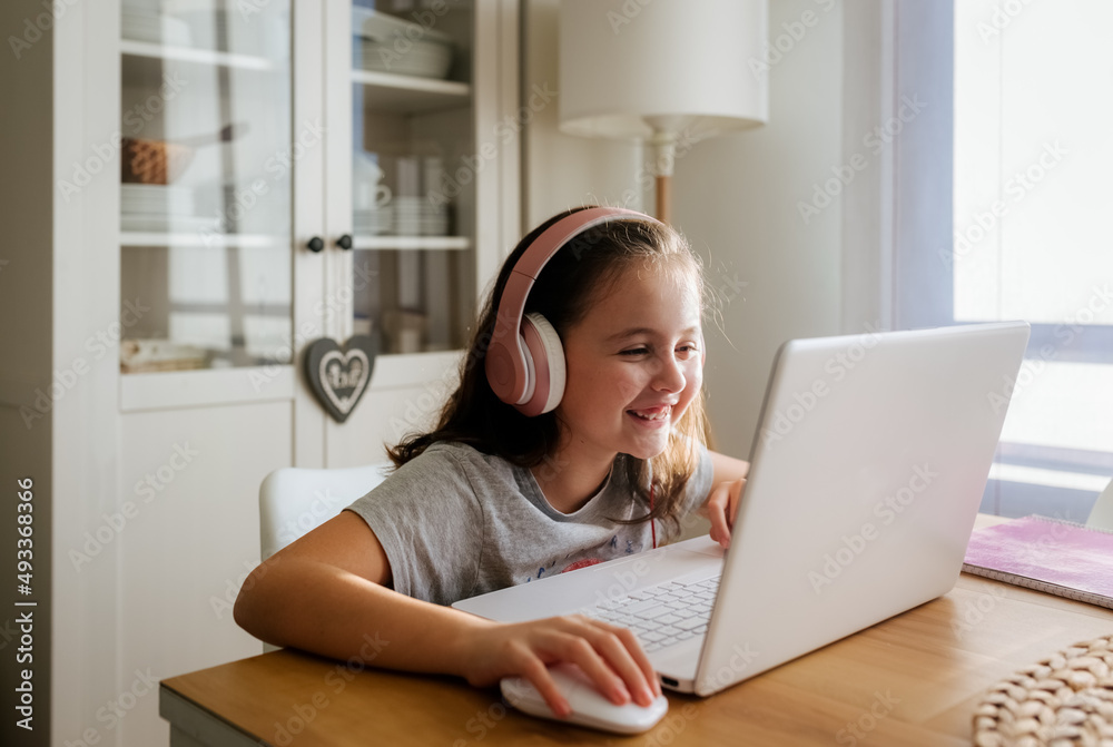 Little girl using a laptop at home Little girl using a laptop at home