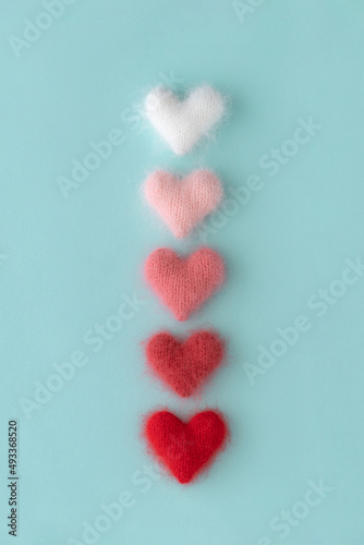 Knitted fluffy hearts on light blue background photo