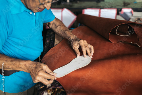 Close up of a shoemaker working with a template photo