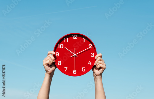 man has a red clock in his hands photo