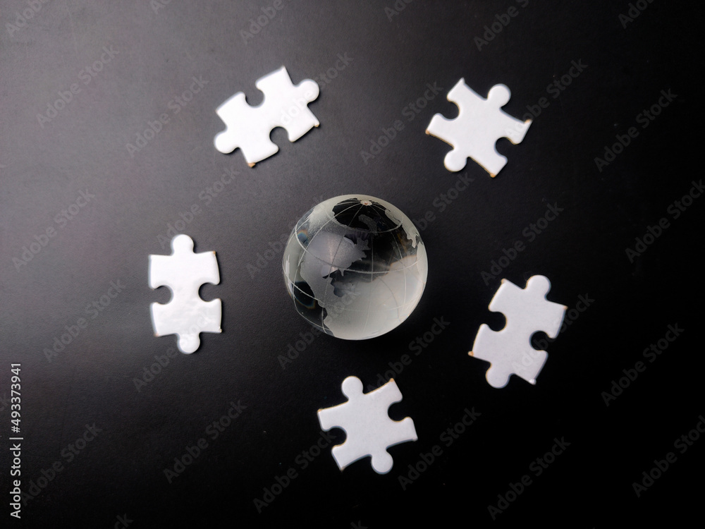 Earth crystal ball with white jigsaw puzzle on a black background. Earth crystal ball with white jigsaw puzzle on a black background.
