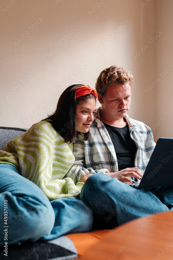 Two young friends using a laptop