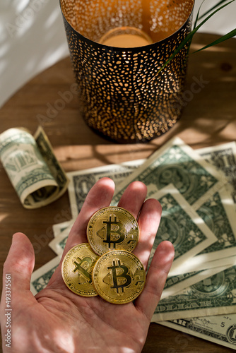 Man holds three Bitcoins