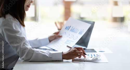 Print op canvas Business woman using calculator for do math finance on wooden desk in office and