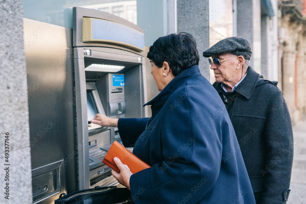 Couple withdrawing money from cash machine Couple withdrawing money from cash machine