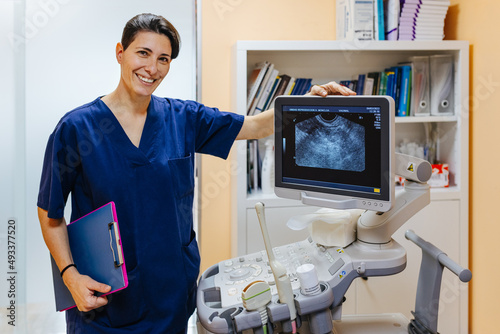 Gynaecologist posing next to an ultrasound unit photo