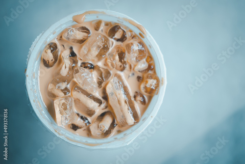 A cup of iced Mocha coffee with ice cubes in a coffee shop.