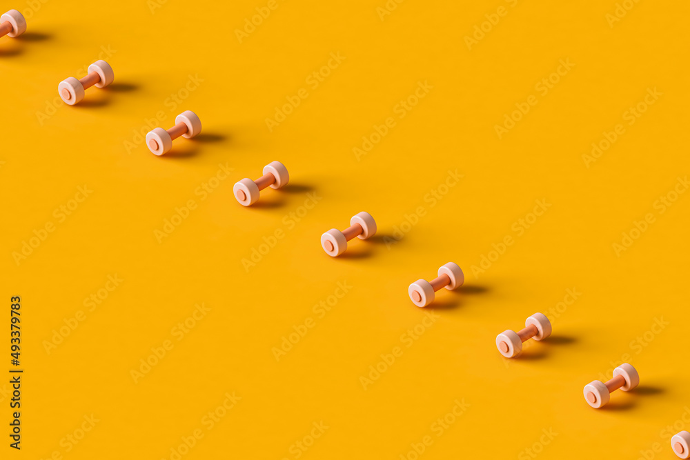 a row of pink dumbbells. with copy space. a row of pink dumbbells. with copy space.