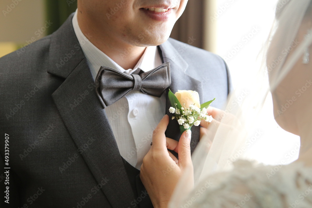 the bride helps put the corsage on the groom the bride helps put the corsage on the groom