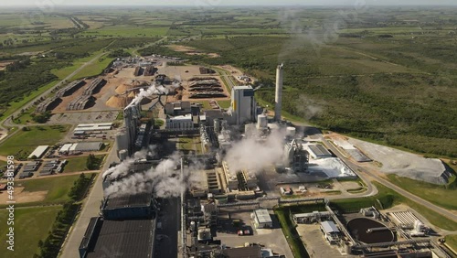 Smoking chimneys in paper mill factory and surrounding landscape, Fray Bentos in Uruguay. Aerial panoramic view photo