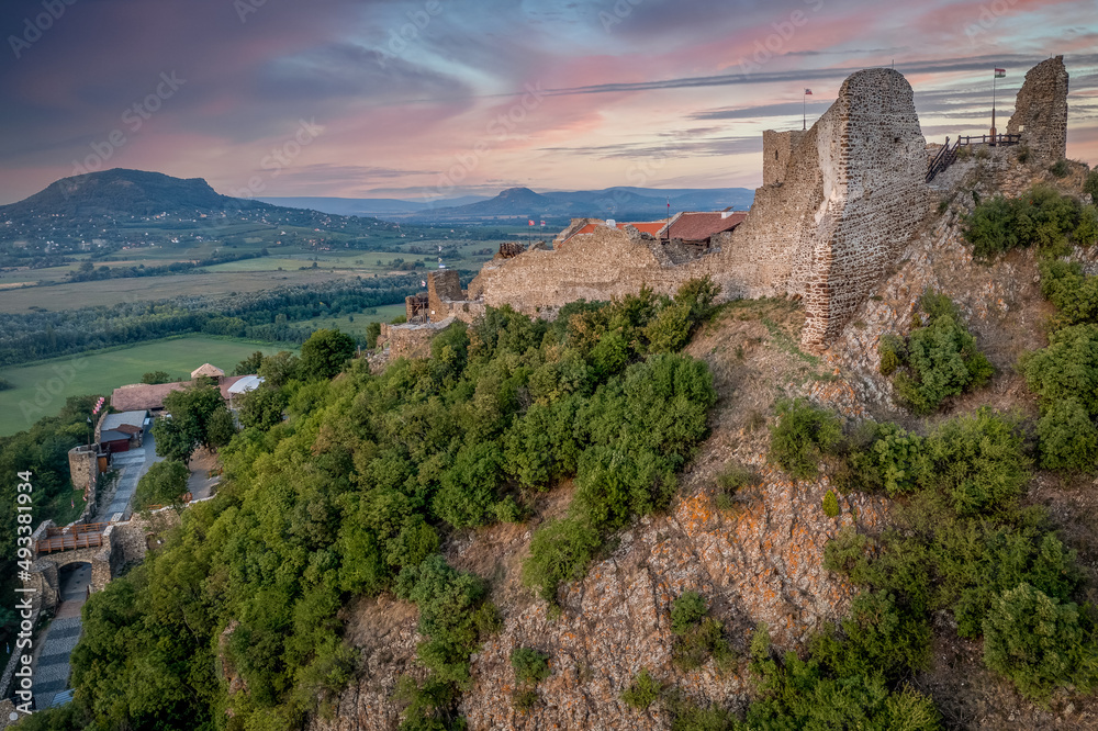 Aerial view of Szigliget castle near lake Balaton with newly restored walls, gate tower, palace building sunset colorful sky Aerial view of Szigliget castle near lake Balaton with newly restored walls, gate tower, palace building sunset colorful sky