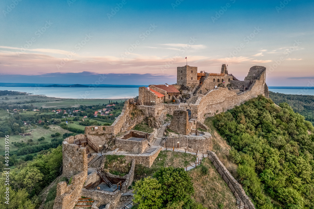 Aerial view of Szigliget castle near lake Balaton with newly restored walls, gate tower, palace building sunset colorful sky