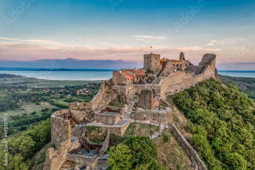 Aerial view of Szigliget castle near lake Balaton with newly restored walls, gate tower, palace building sunset colorful sky