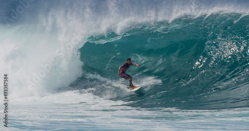 Surfer surfing big tropical wave barrel tube at Banzai Pipeline in Hawaii
