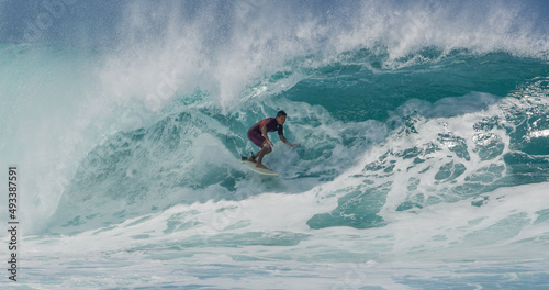Surfer surfing big tropical wave barrel tube at Banzai Pipeline in Hawaii