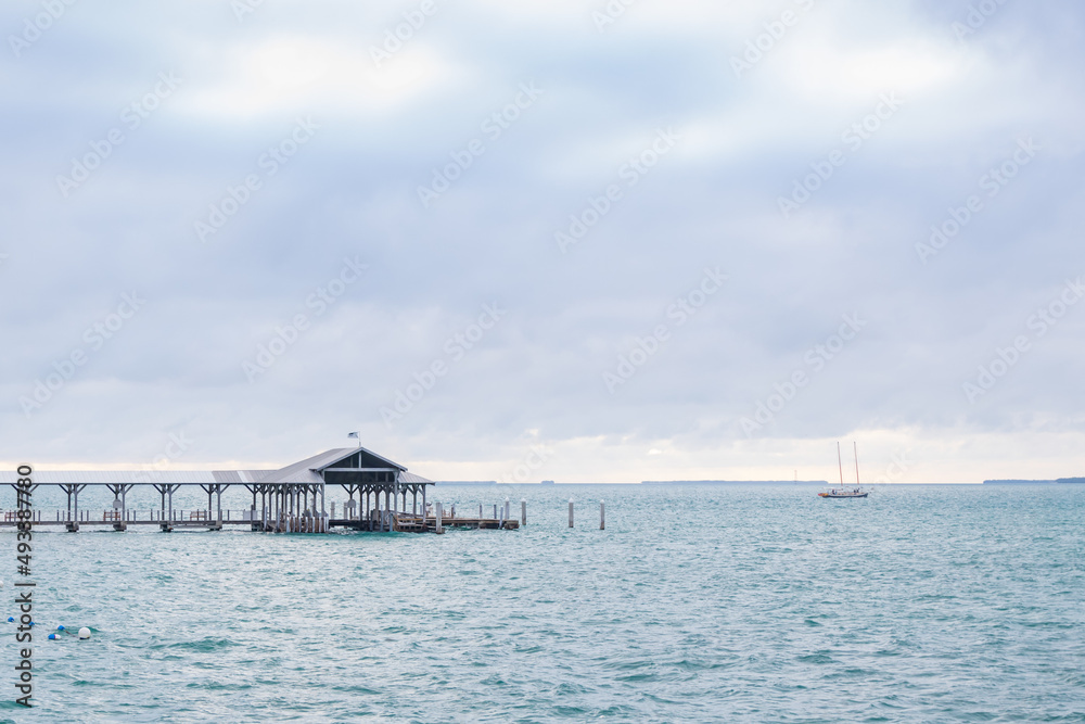 Obraz premium Boathouse and pier, storm clouds background