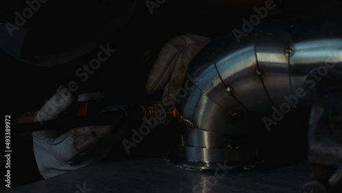 Close up of a fabricator TIG welding stainless steel exhaust pipe with pie cuts. 
Semi close static shot. photo