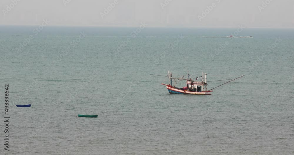 Thai Fishing Vessel Anchored with Two Smaller Boats Nearby off the Coast of Pattaya, Thailand. Thai Fishing Vessel Anchored with Two Smaller Boats Nearby off the Coast of Pattaya, Thailand.