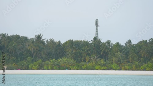 Telecommunication tower in the tropical island. Telecom tower antennas and satellite transmits the signals of cellular 5g 4g mobile signals and their radio waves works on a long distance. Green palms