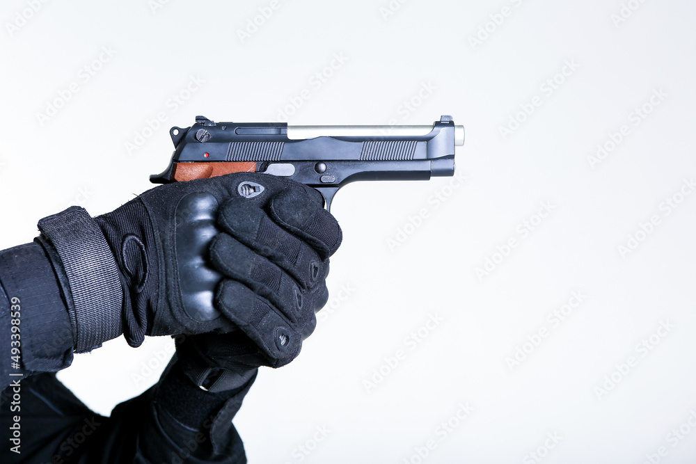 the hands of a soldier are holding a gun close up isolated on white background