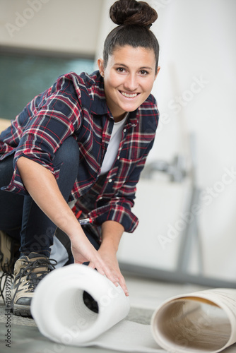 a female worker unrolling carpet photo