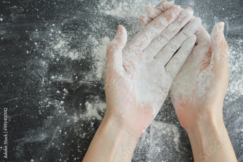 Hands covered by cornstarch on a black table top background