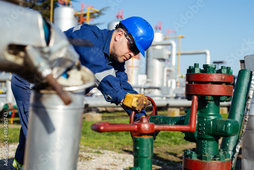 Oil worker turning valve on oil rig