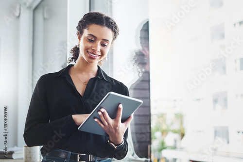 Managing her day-to-day tasks with the smartest apps. Shot of a young businesswoman using a digital tablet in an office. photo