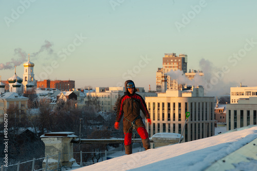 A climber cleans the roof from snow 
