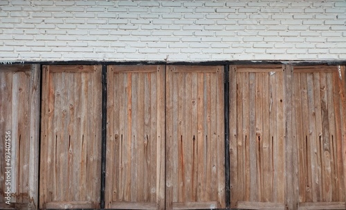 An old wooden window is installed in a beautiful white brick wall to serve as a background.