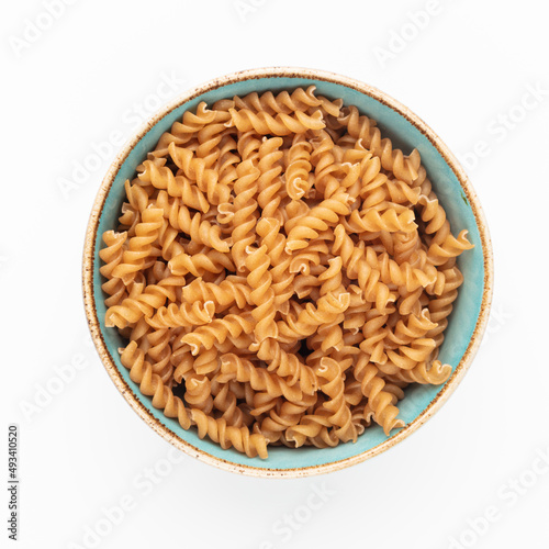 Whole fusilli pasta in a wooden bowl.