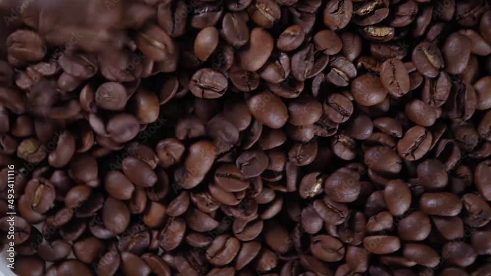 Closeup video of pouring coffee beans, rotating top view roasted brown coffee beans Closeup video of pouring coffee beans, rotating top view roasted brown coffee beans