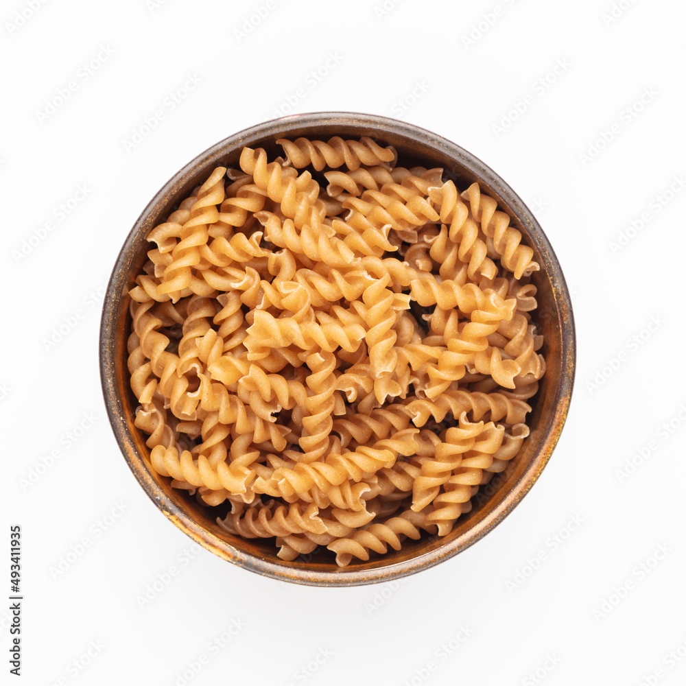 Whole fusilli pasta in a wooden bowl. Whole fusilli pasta in a wooden bowl.