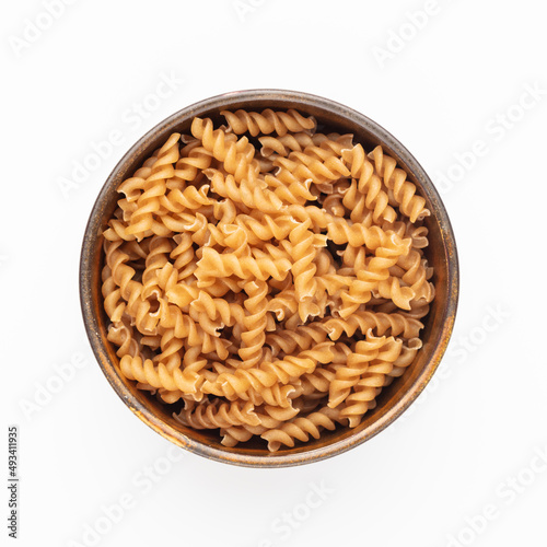 Whole fusilli pasta in a wooden bowl.