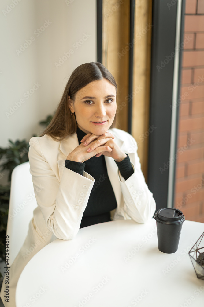 young woman sitting in a cafe at a table