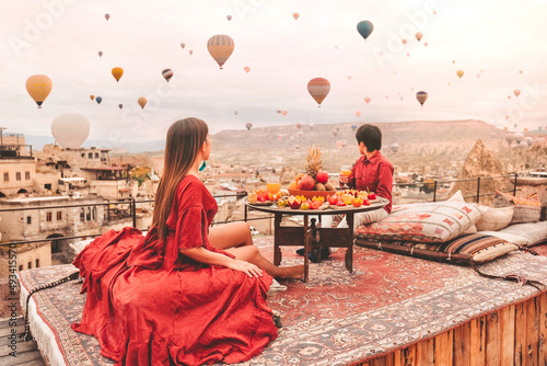 Couple Travel in Cappadocia Colorful hot air balloons flying over the valley sunrise time with special breakfast travel destination in Turkey