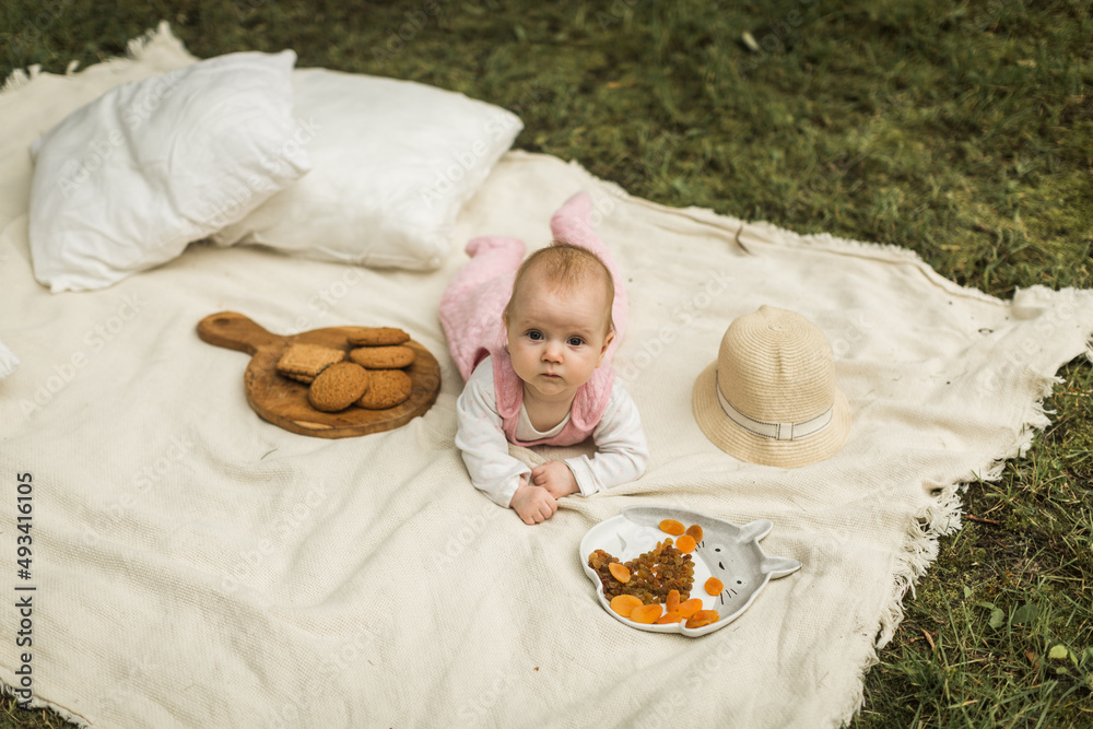 little girl resting on a blanket in the park