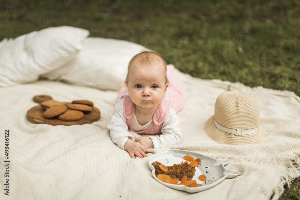 little girl resting on a blanket in the park