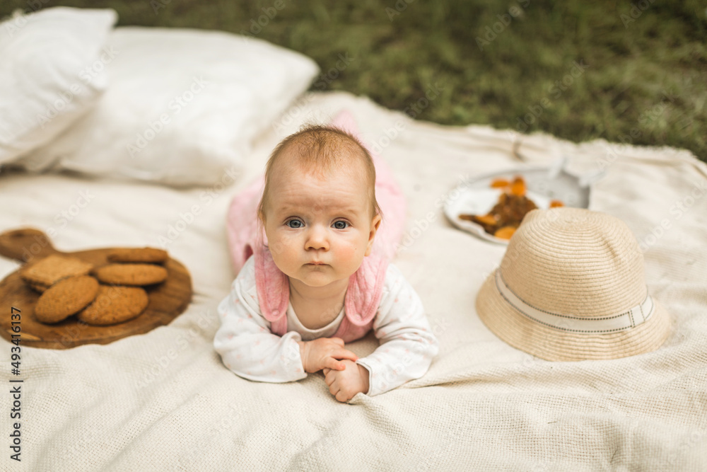 little girl resting on a blanket in the park