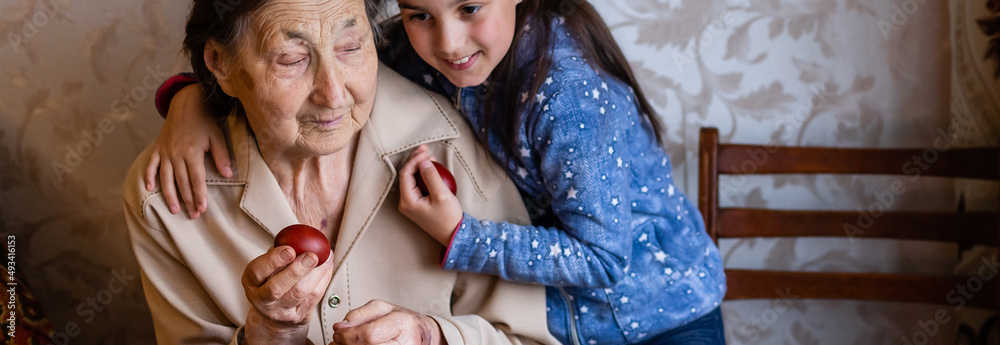Obraz premium senior woman with easter eggs and Easter cake