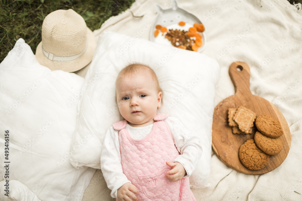 little girl resting on a blanket in the park