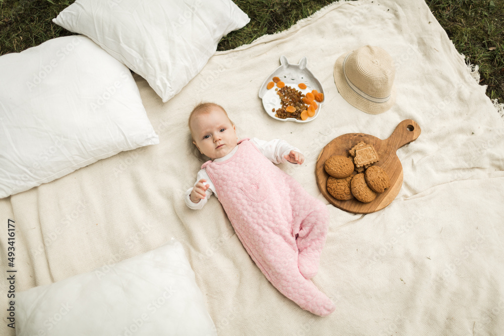 little girl resting on a blanket in the park