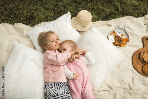 Obraz na płótnie two little sisters play on the picnic w salonie