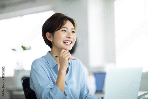 デスクで笑顔で仕事をする女性