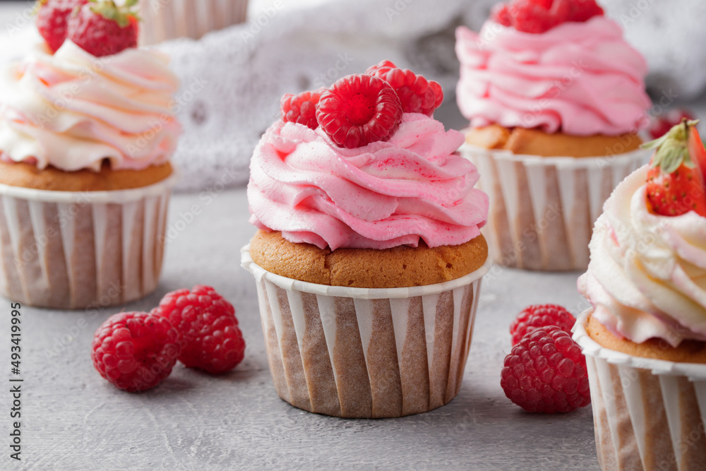 Pink cupcakes with cream and fresh berries