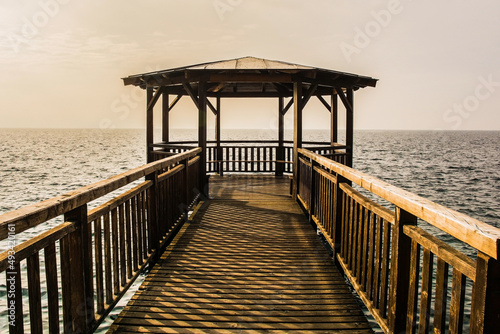 A wooden covered pier on the waterfront of Garda town on the east shore of lake Garda, Verona Province, Veneto, north east Italy
